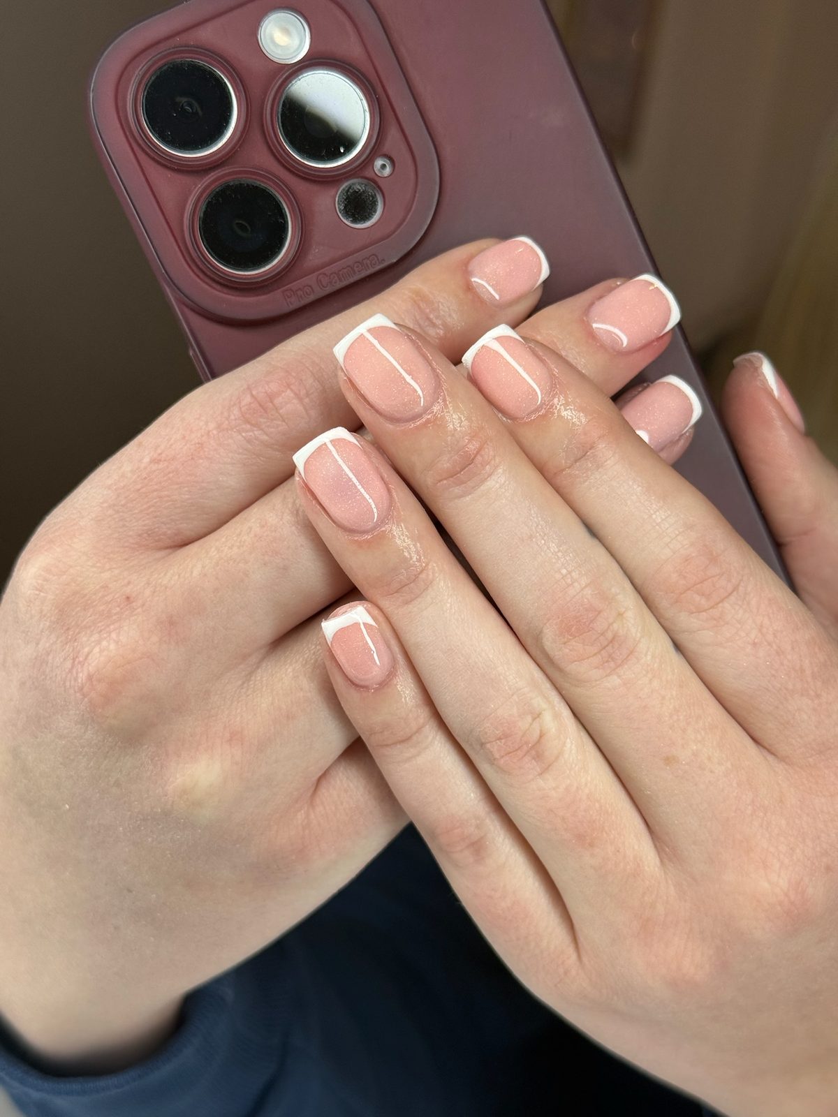 French manicure op korte nagels, handen over elkaar