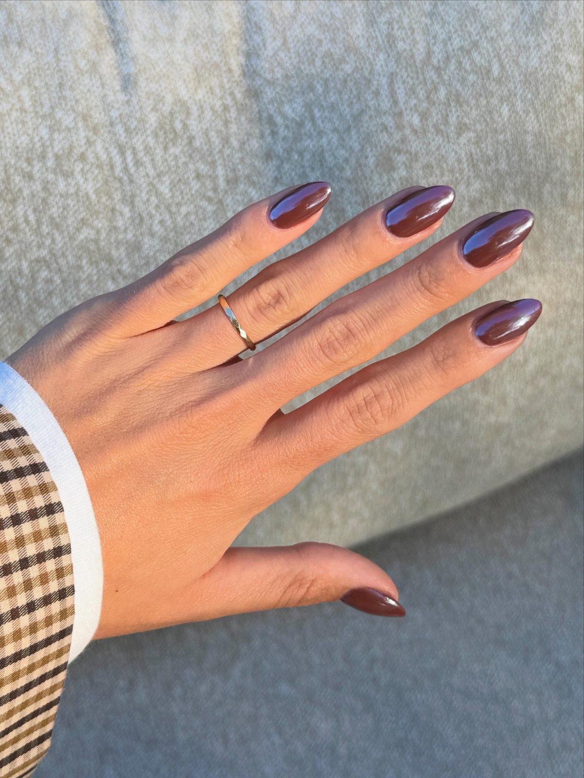 Gel-X set met paarse chrome, rug van de hand op een grijze plaid