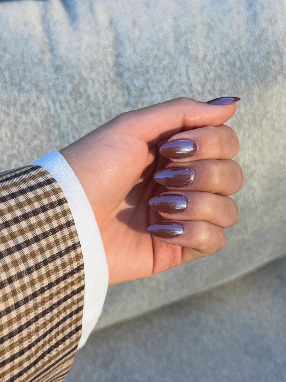 Chrome Gel-X set, hand in een vuist naast een geruite mouw
